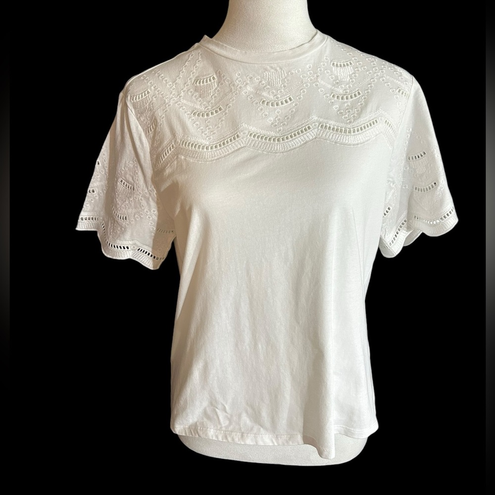 An Ophelia Roe short sleeved white pullover blouse with top and sleeve eyelets